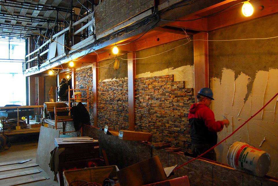 Men installing Norstone stacked stone panels on performing arts center in Boston Massachusetts